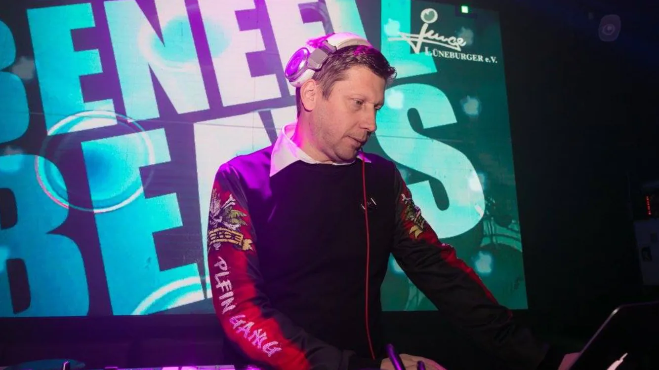 Sven performing in front of a branded event screen