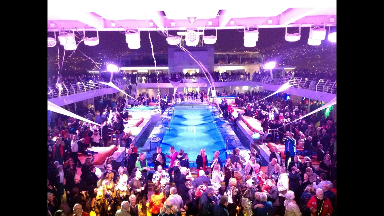 Large international crowd facing a colorful stage production