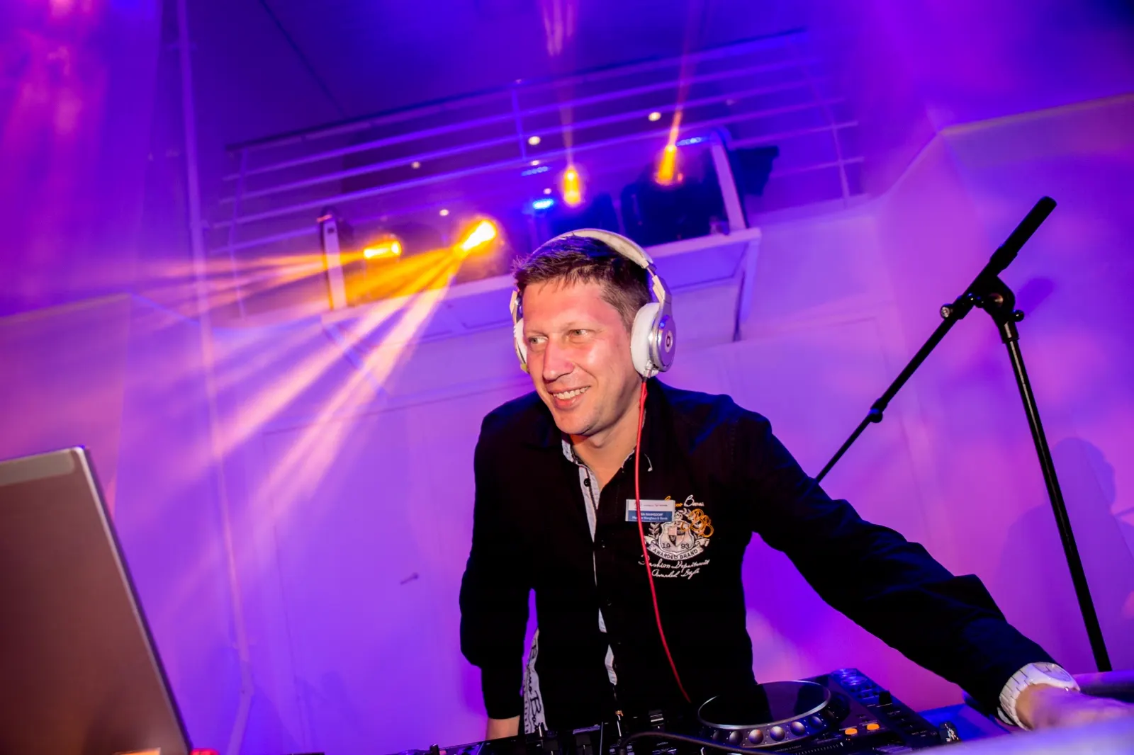 Sven Rahmsdorf DJing under stage lights on a cruise ship
